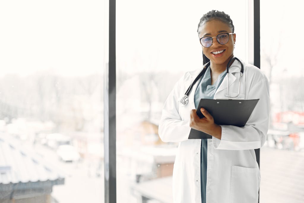 Professional female doctor smiling confidently holding a clipboard indoors.